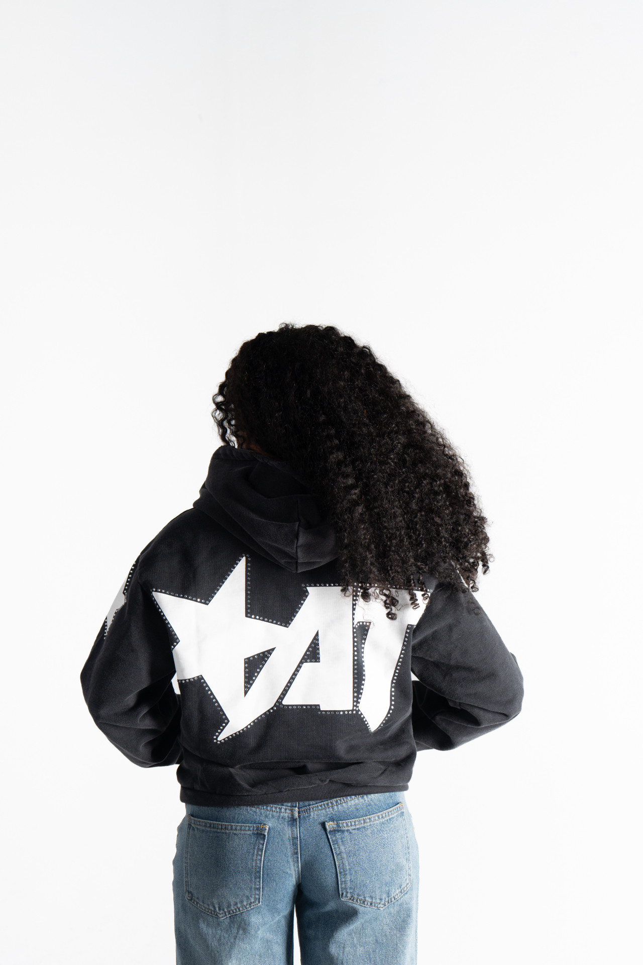 Female model wearing the black Starstruck Hoodie, showing the back star graphic
