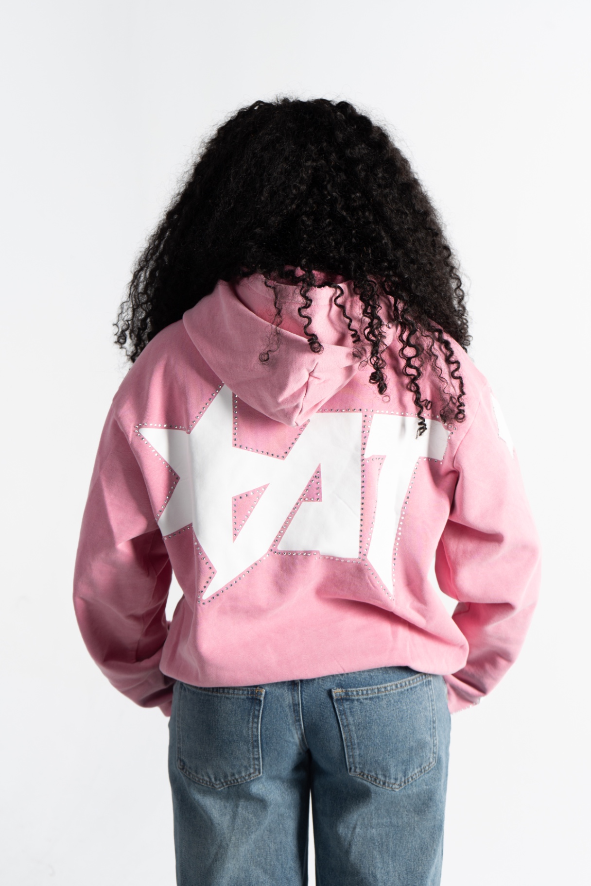 Female model wearing the pink Starstruck Hoodie, showing the back star graphic